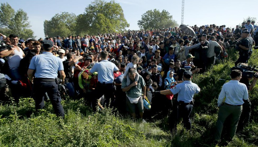 Policemen direct migrants during a stampede to board a bus in Tovarnik, Croatia September 17, 2015.  REUTERS/Antonio Bronic